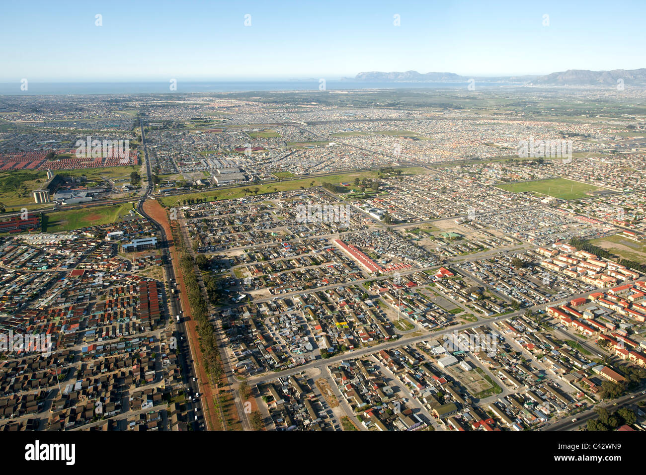 Vista aerea guardando a sud di Nyanga township e giù la M22 (nuovo Eisleben road) verso False Bay a Cape Town, Sud Africa Foto Stock
