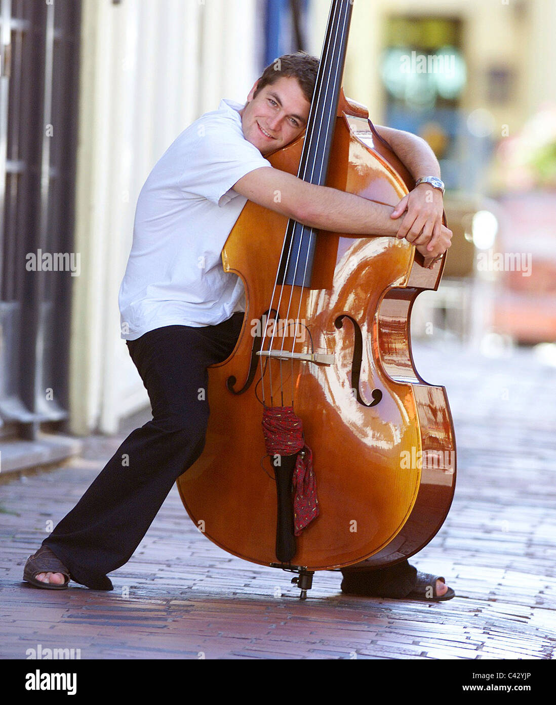 Musicista Nick McGuigan avvolge il suo double bass in Brighton Lanes. Foto Stock