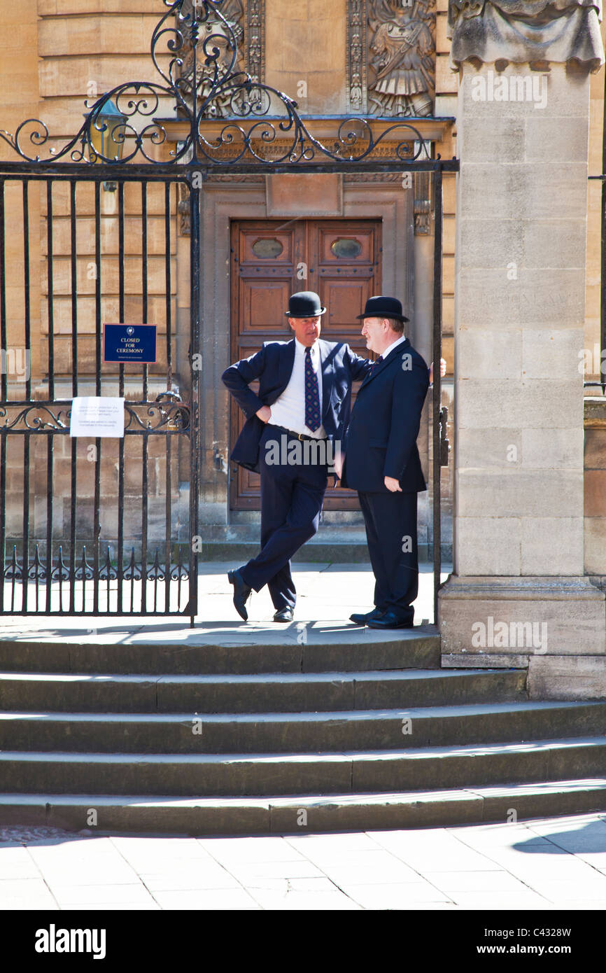 Due Oxford 'Bulldog' in tradizionale Bowler Hats fuori Sheldonian Theatre, Università di Oxford, Oxford, England, Regno Unito Foto Stock