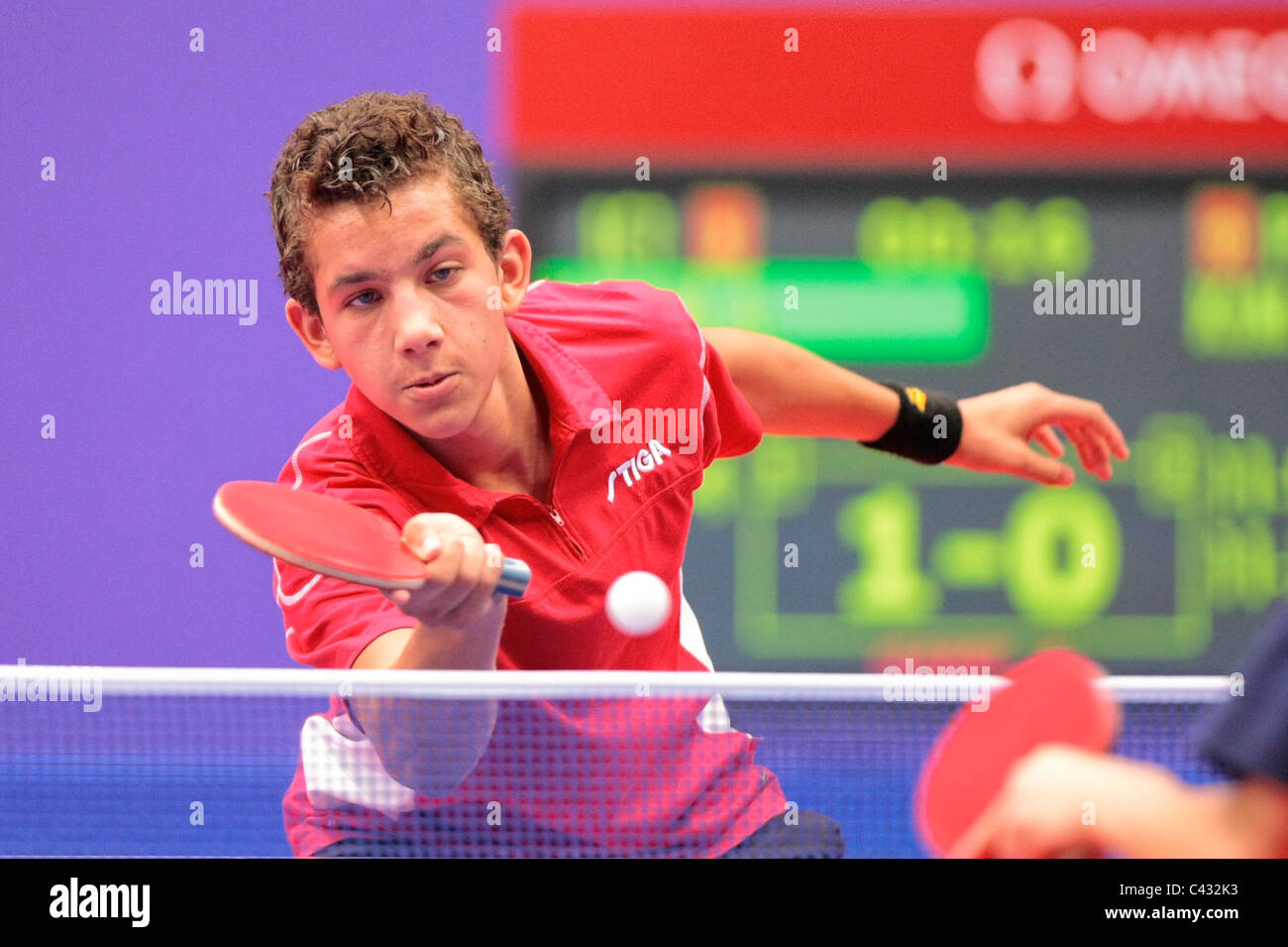 La Tunisia è Adem Hmam del Team InterContinental1 competere nelle Olimpiadi della Gioventù Ping Pong Team misti 3 posto playoff. Foto Stock