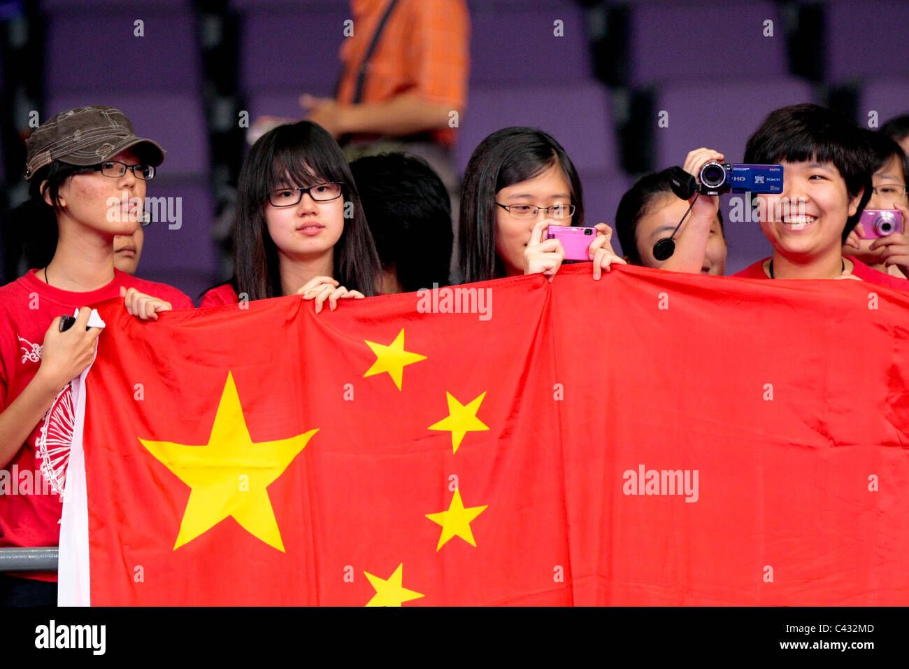 Sostenitori cinesi in pieno vigore per supportare Gu Yuting nel 2010 Olimpiadi della Gioventù Team misti 3 posto playoff. Foto Stock