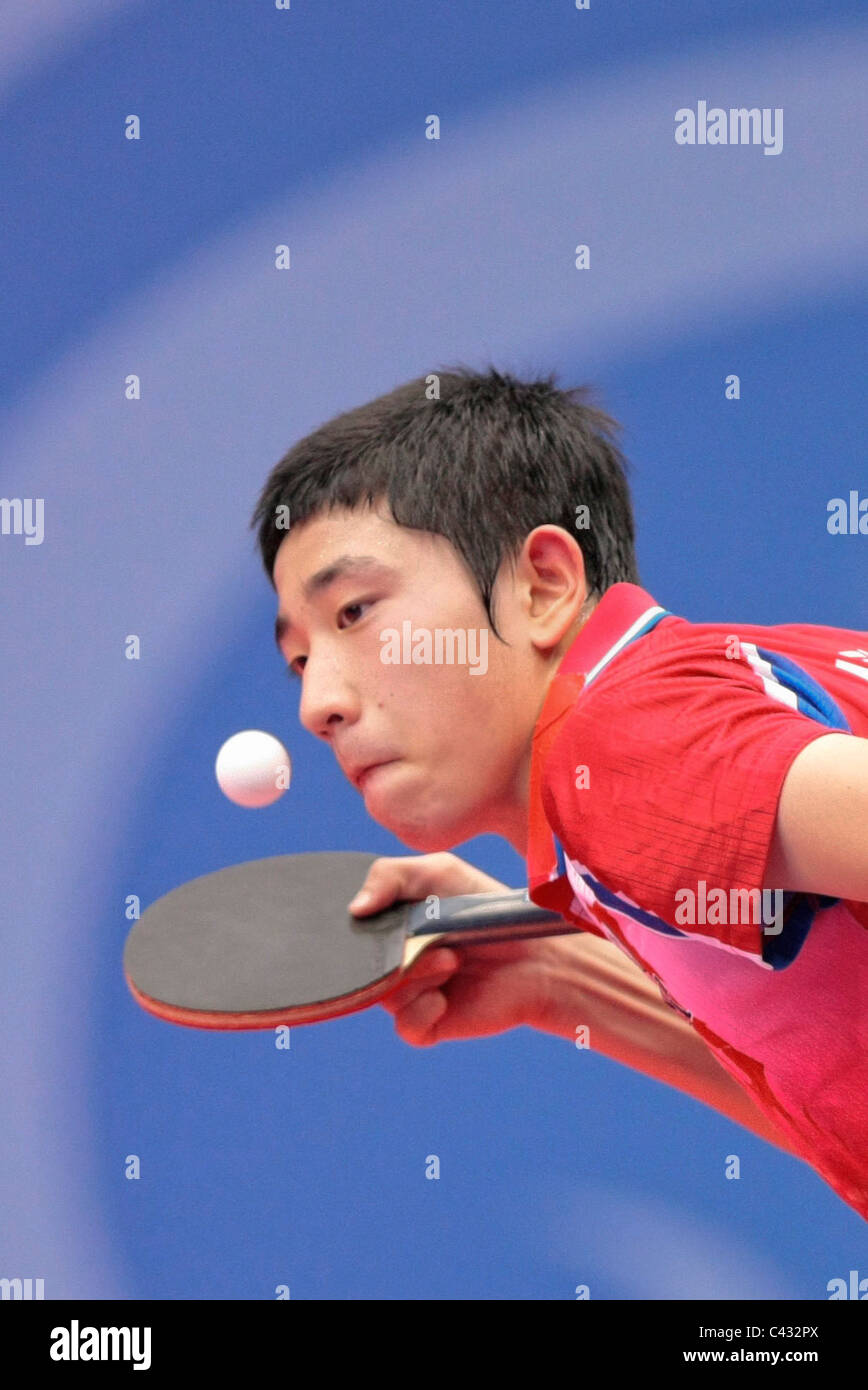 Kim Dong Hyun della Corea del team competere nel 2010 Singapore Olimpiadi della Gioventù Ping Pong Team misti finali. Foto Stock