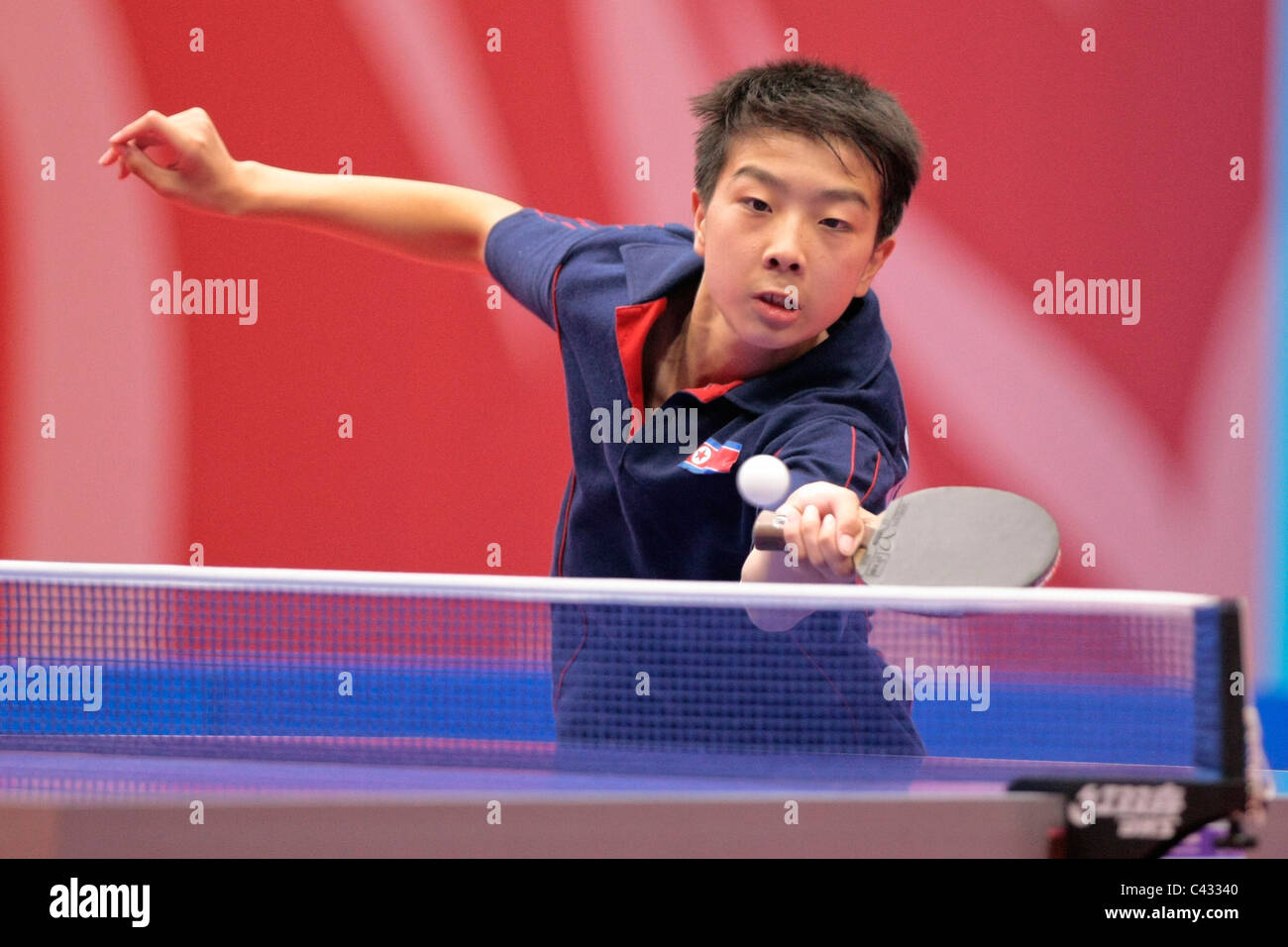 Kim Kwang canzone del Team RPD di Corea competere nel 2010 Singapore Olimpiadi della Gioventù Ping Pong Team misti 3 posto playoff. Foto Stock