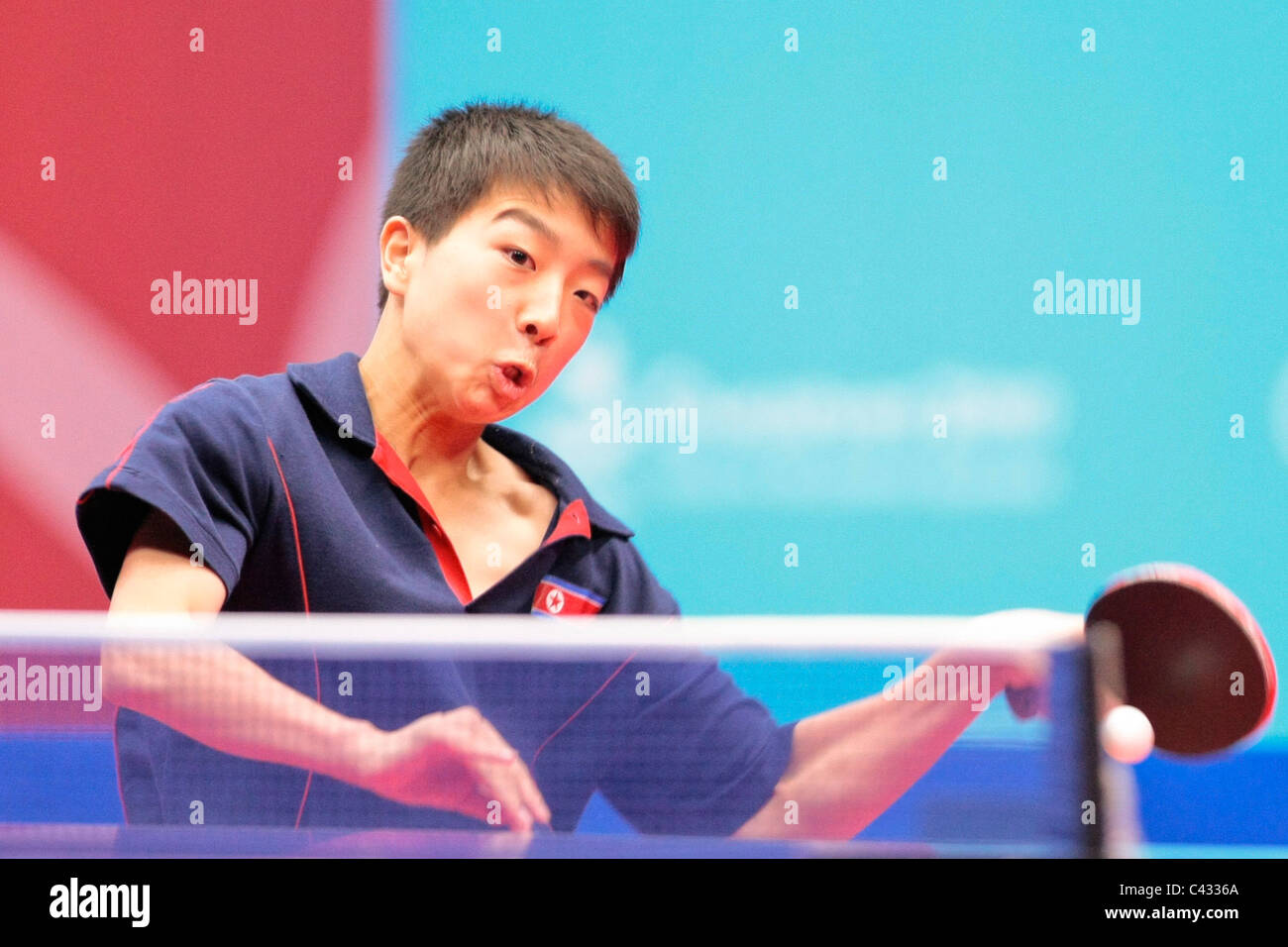 Kim Kwang canzone del Team RPD di Corea competere nel 2010 Singapore Olimpiadi della Gioventù Ping Pong Team misti 3 posto playoff. Foto Stock