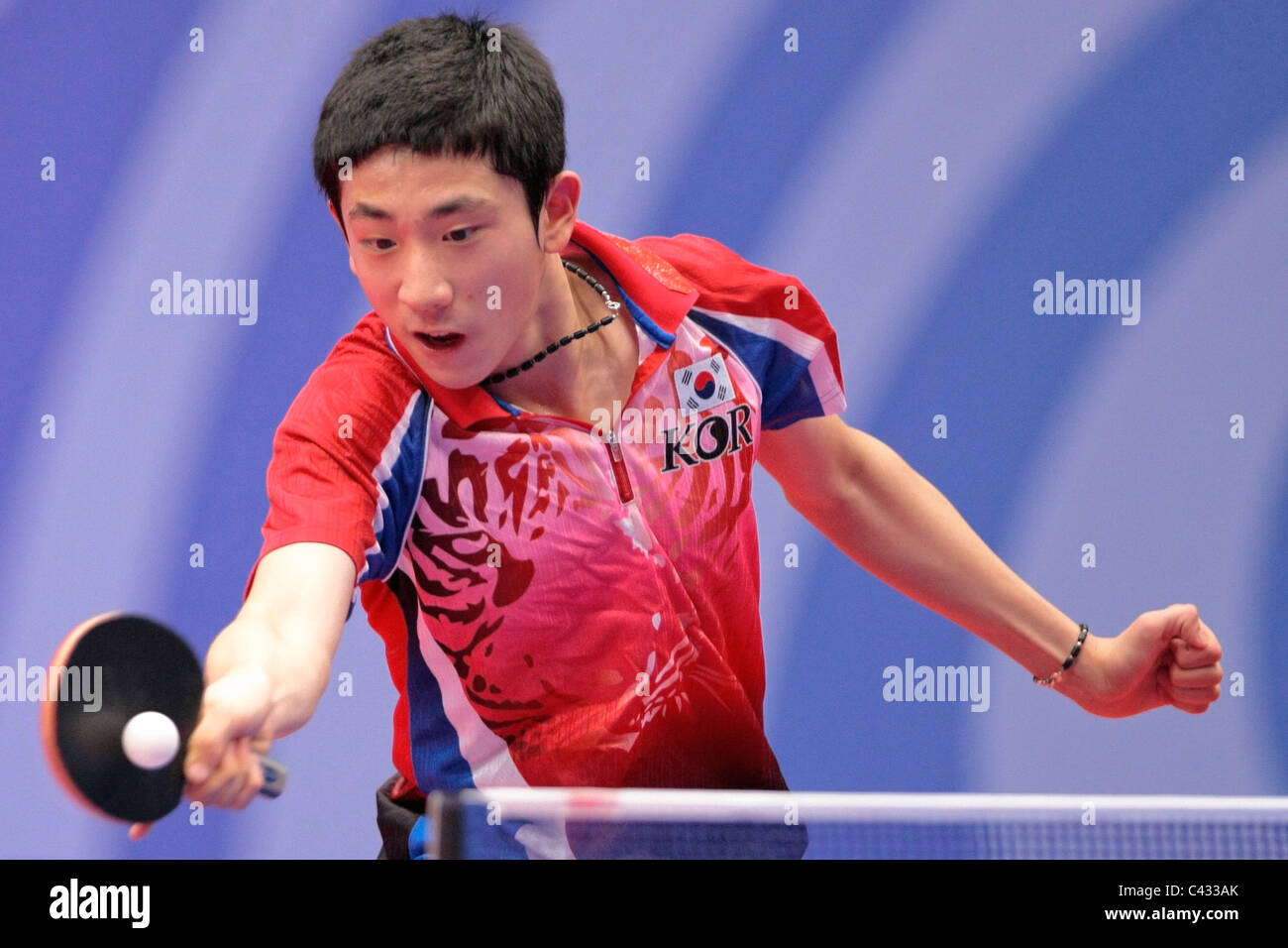 Kim Dong Hyun della Corea del team competere nel 2010 Singapore Olimpiadi della Gioventù Ping Pong Team misti finali. Foto Stock