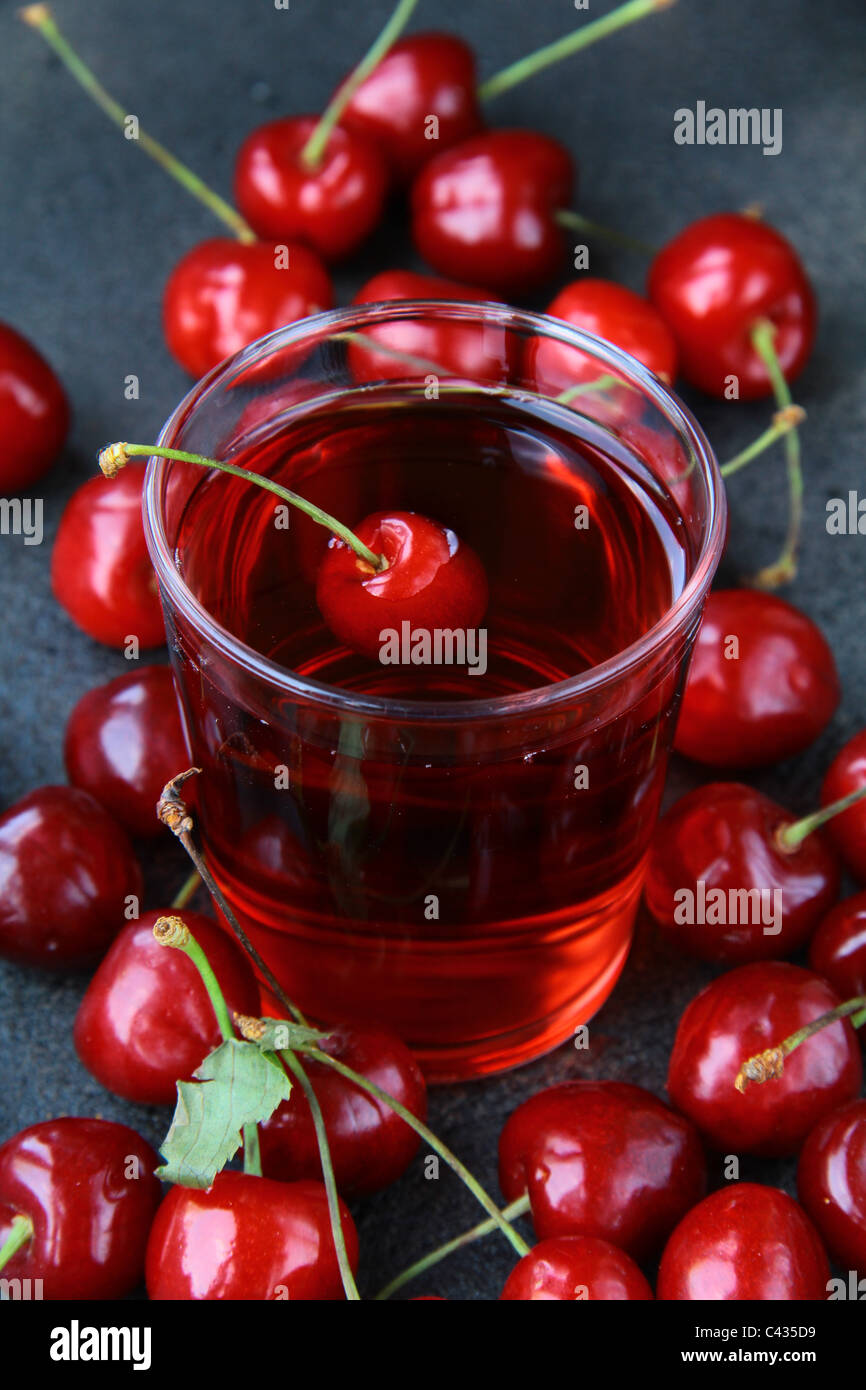 Bicchiere di freschi succhi di ciliegie e le ciliege fresche Foto Stock