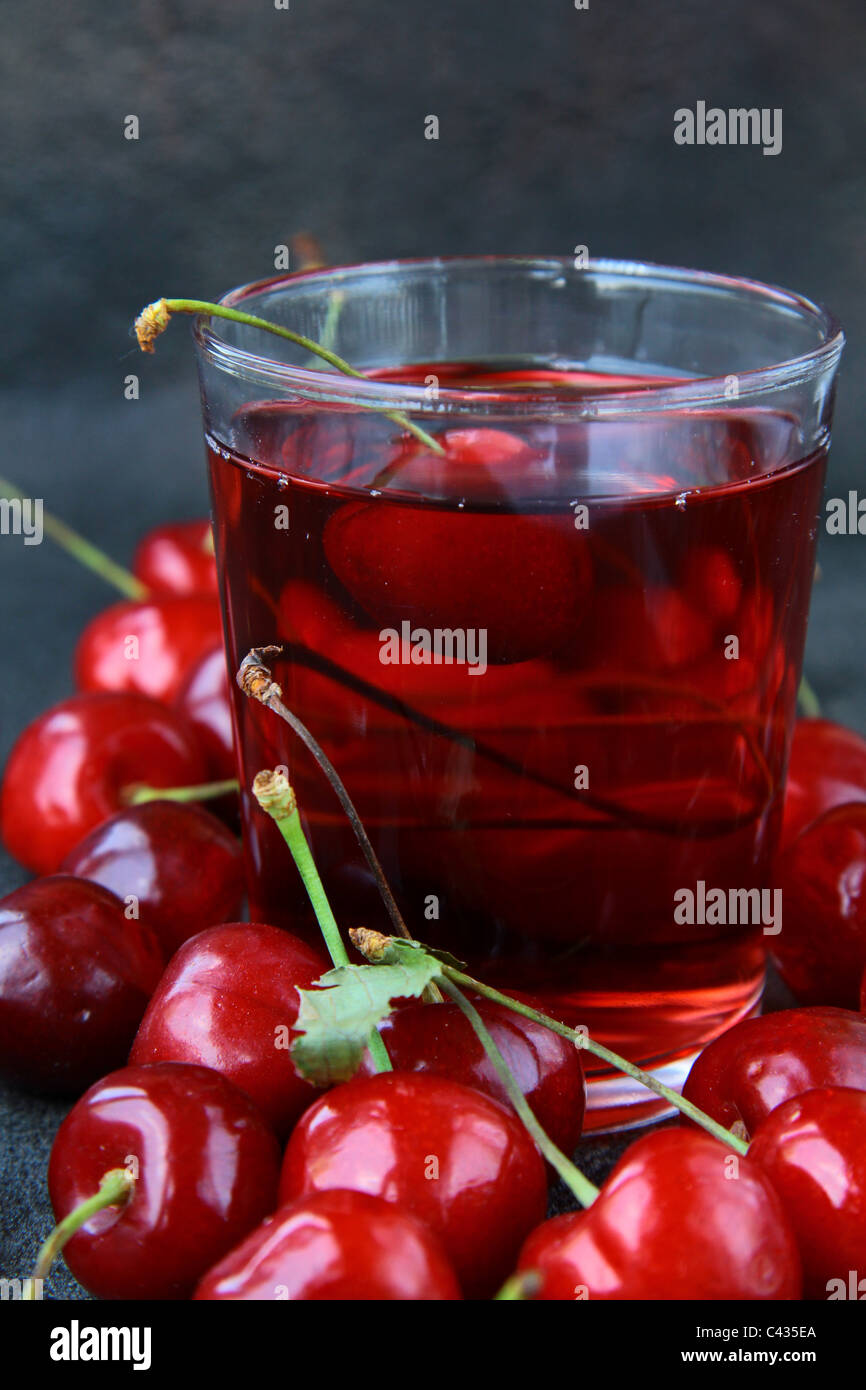 Bicchiere di freschi succhi di ciliegie e le ciliege fresche Foto Stock