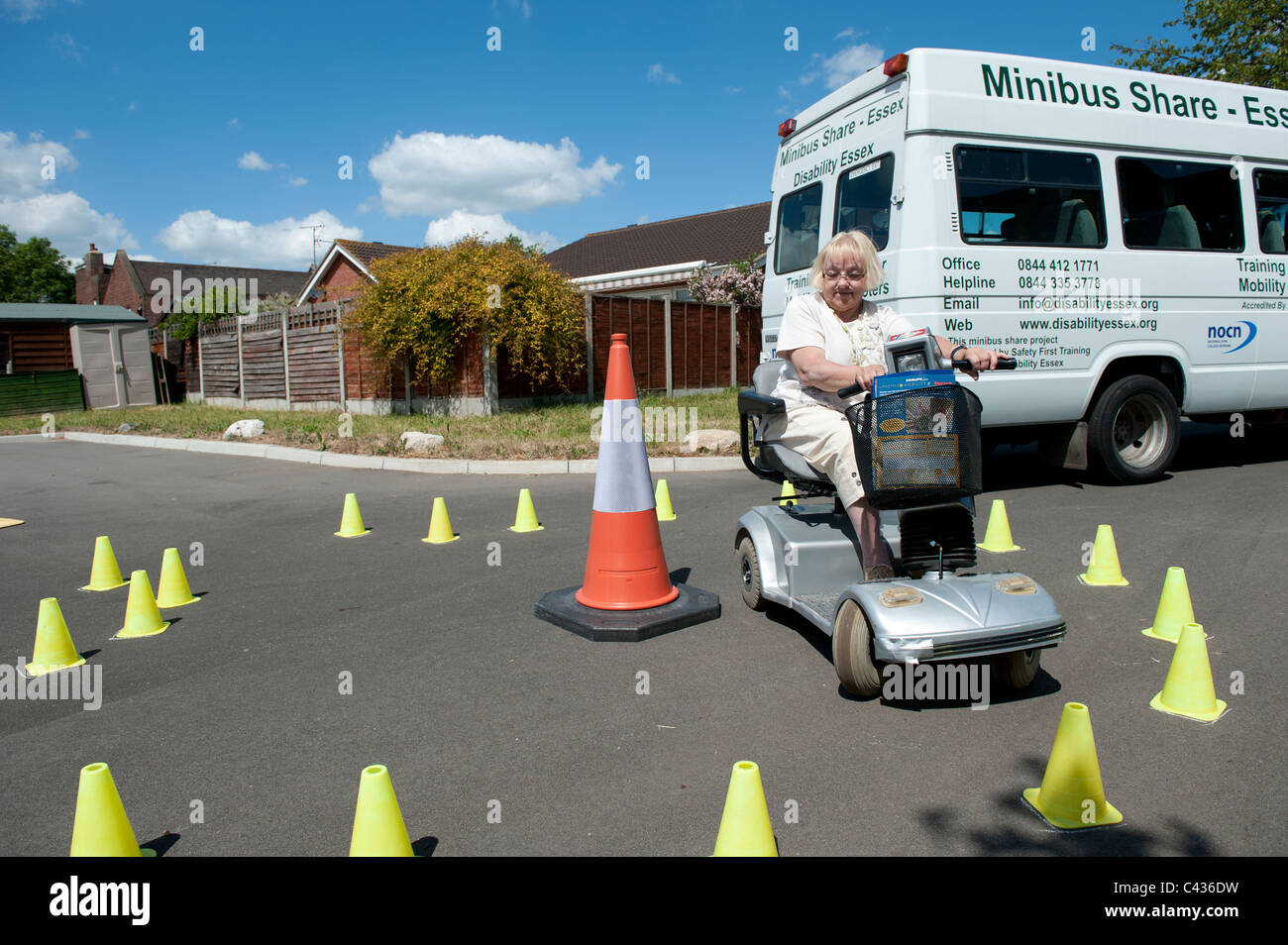 Un anziano (senior) lady imparare a guidare uno scooter di mobilità al Centro per gli studi sulla disabilità a Rochford, Essex. Foto Stock