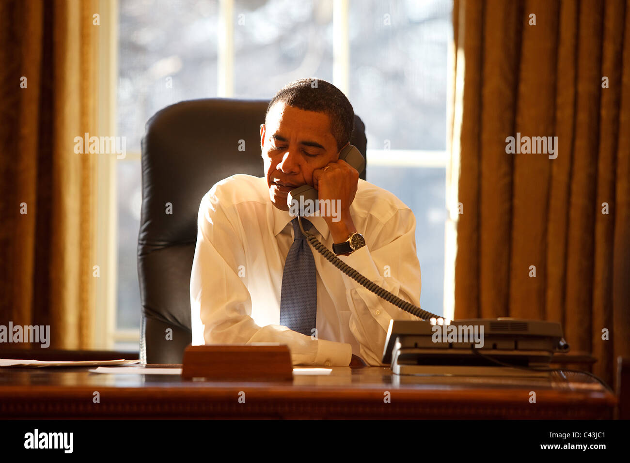 Il presidente Barack Obama parla con un leader straniero nell'ufficio ovale sul suo primo giorno in ufficio Foto Stock