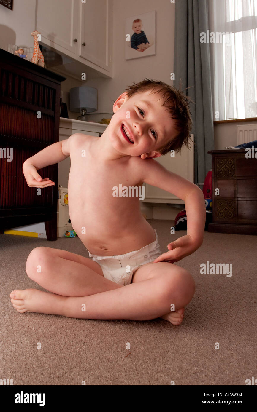 Un giovane bambino in un pannolino a casa (stesso bambino nella foto sulla  parete di fondo Foto stock - Alamy