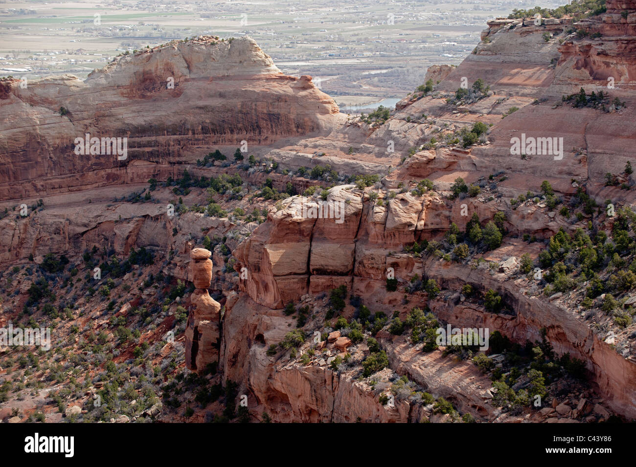 Roccia equilibrato, in Fruita Canyon del Colorado National Monument. La città di Fruita, Colorado è visibile in background Foto Stock