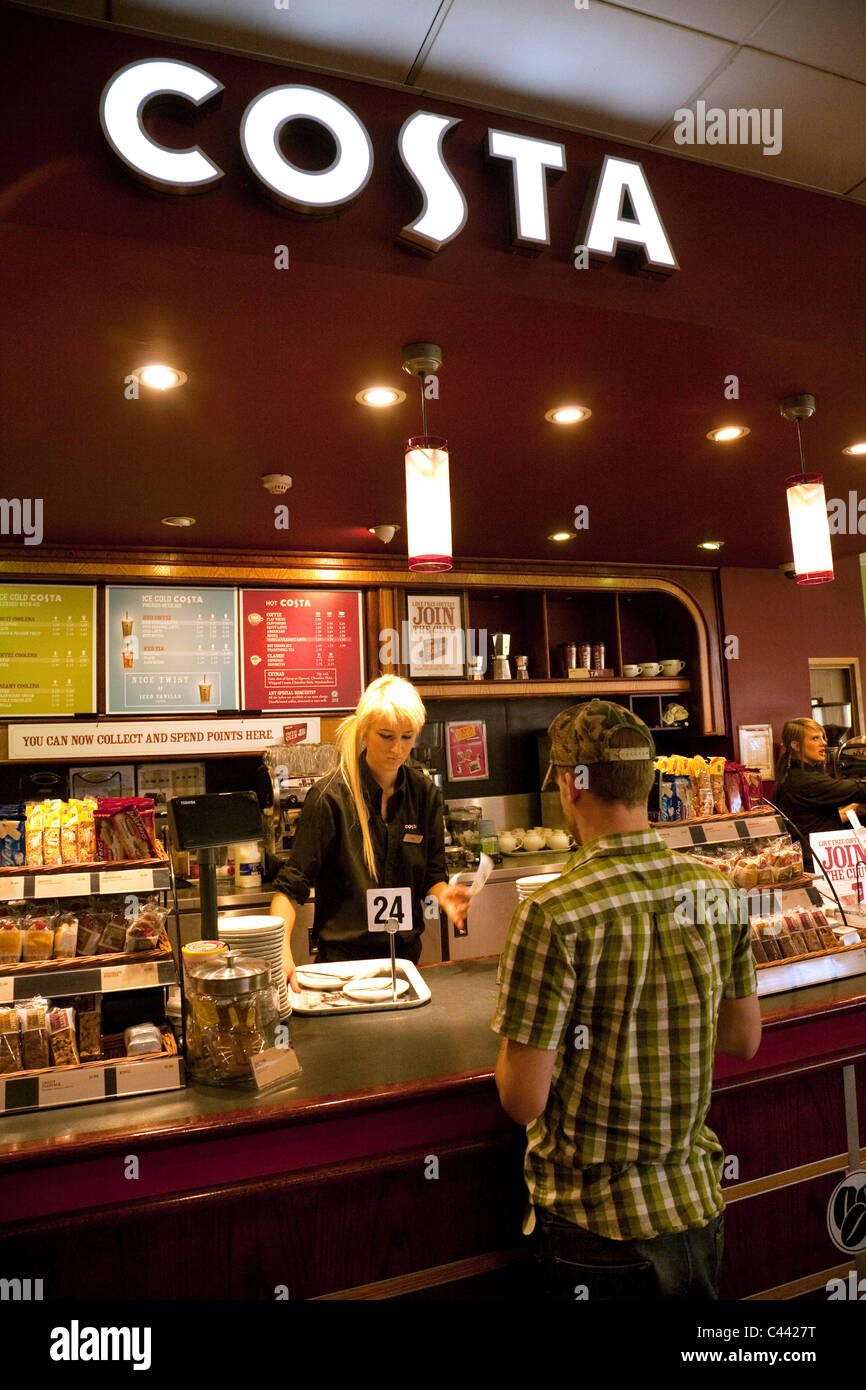 Un barista che serve un cliente, Costa Coffee cafe, Exeter servizi autostradali, M5, Devon, Regno Unito Foto Stock
