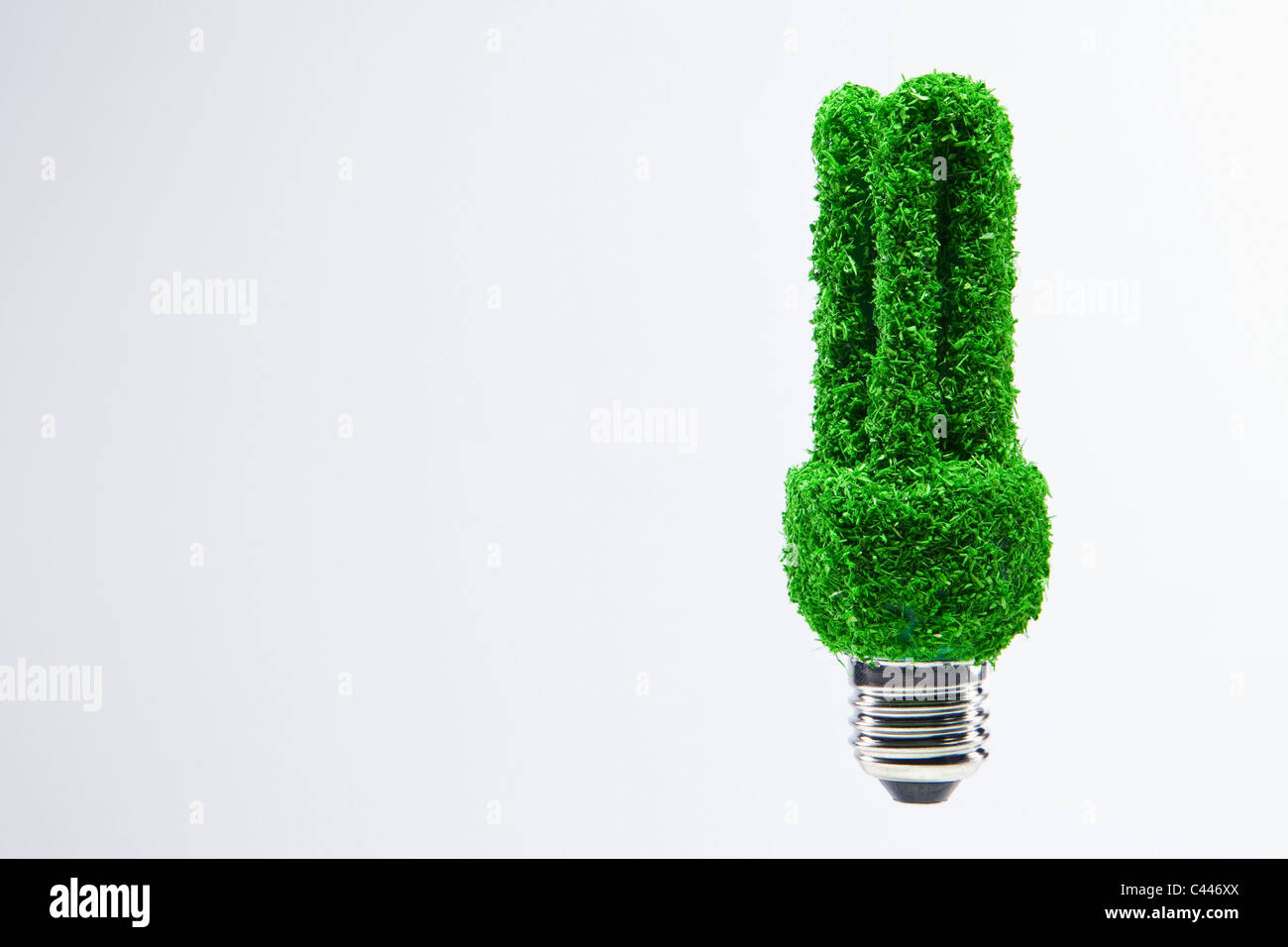 Luce a risparmio energetico la lampadina coperta di verde erba. Foto Stock
