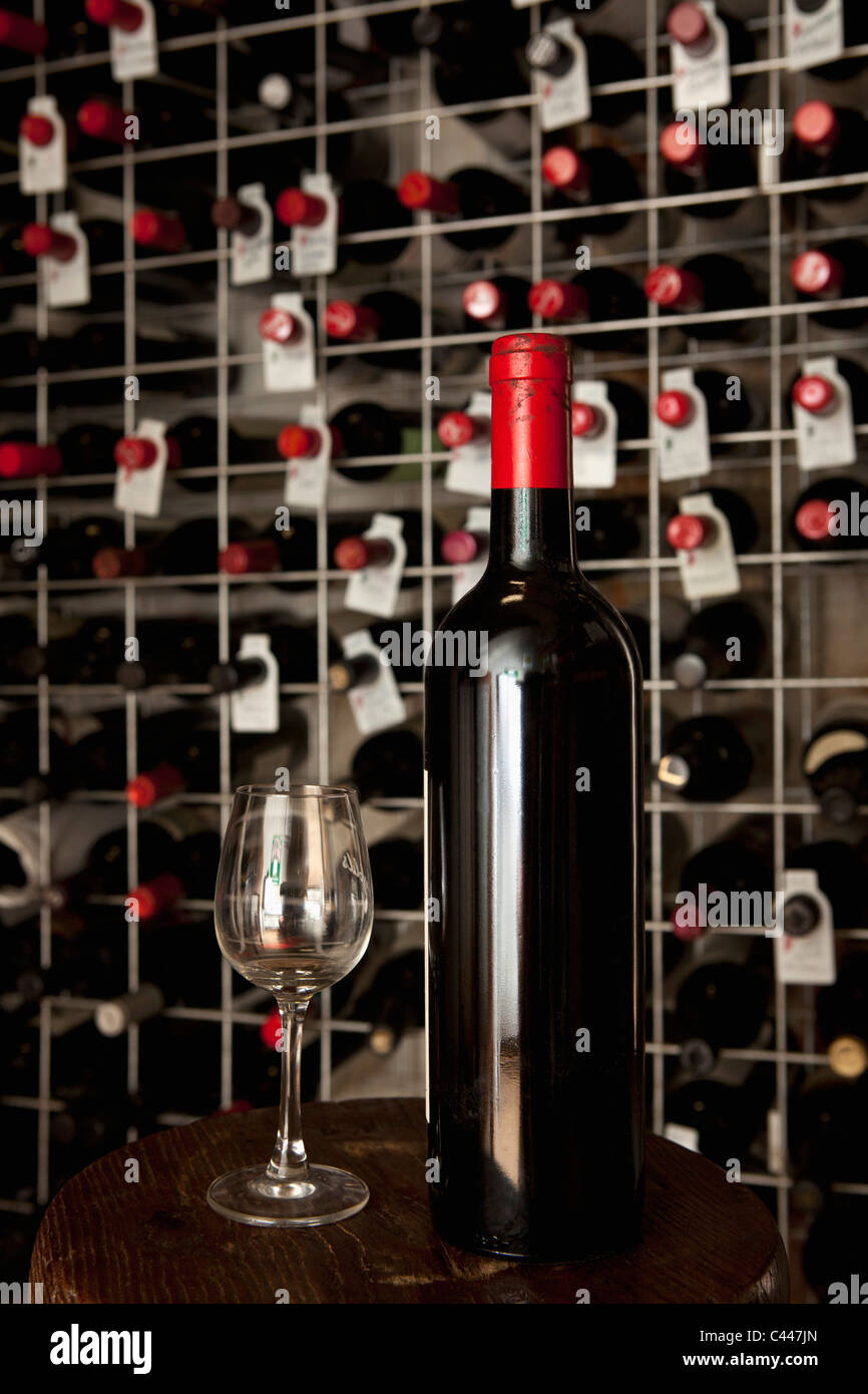 Una bottiglia di vino e un bicchiere in una cantina Foto Stock