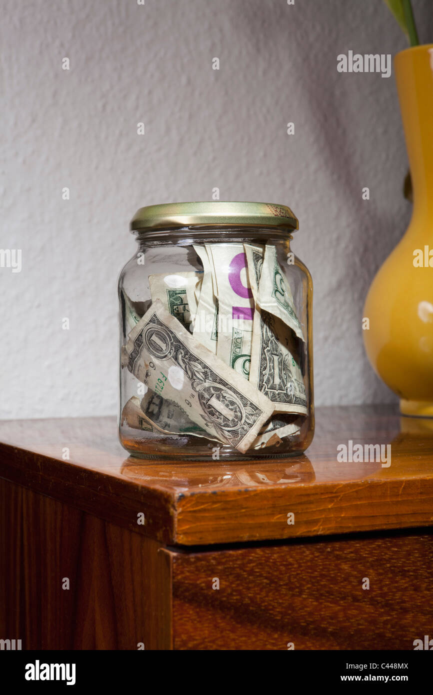 Un vaso pieno di noi carta moneta Foto Stock