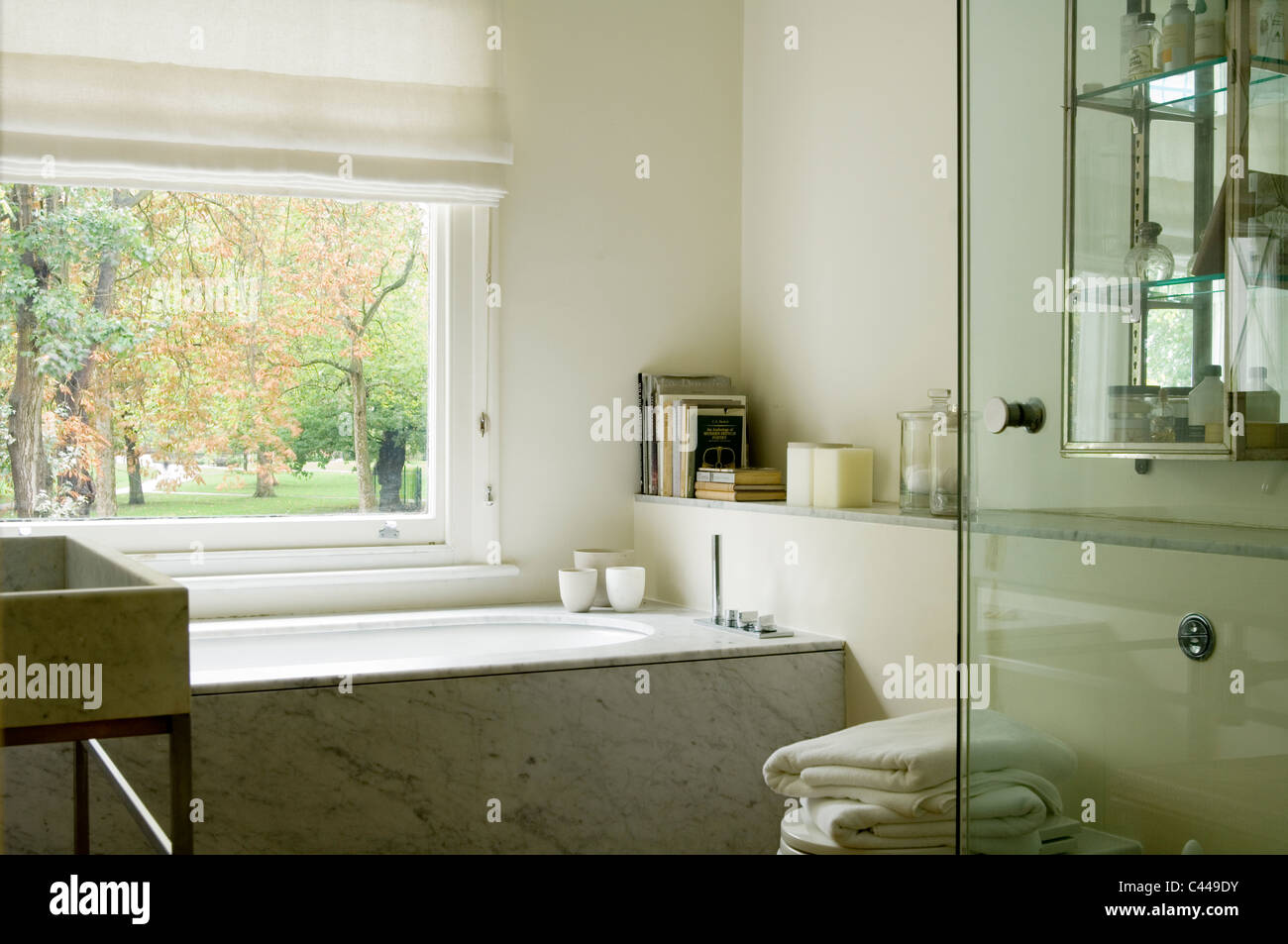Marmo di Carrara vasca da bagno e il lavandino in bagno bianco con grande finestra Foto Stock