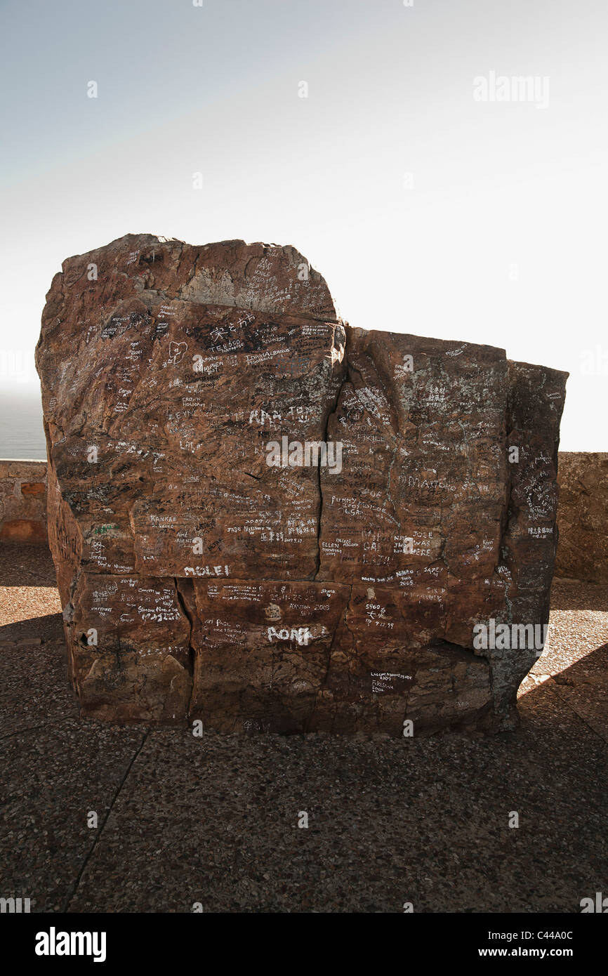 Boulder con messaggi scritti su di esso e la parete circostante in background Foto Stock