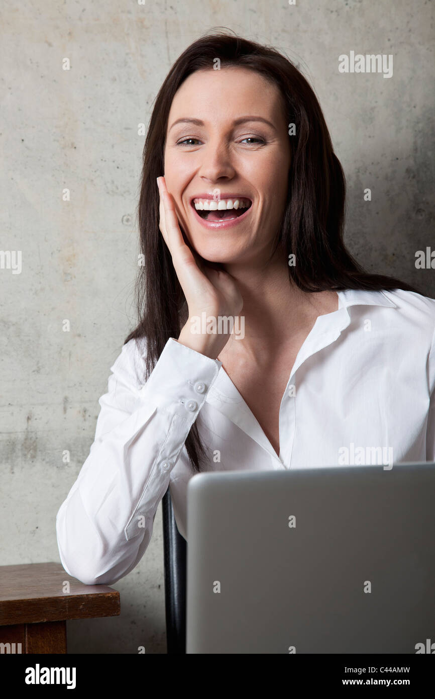 Imprenditrice con un laptop di ridere Foto Stock