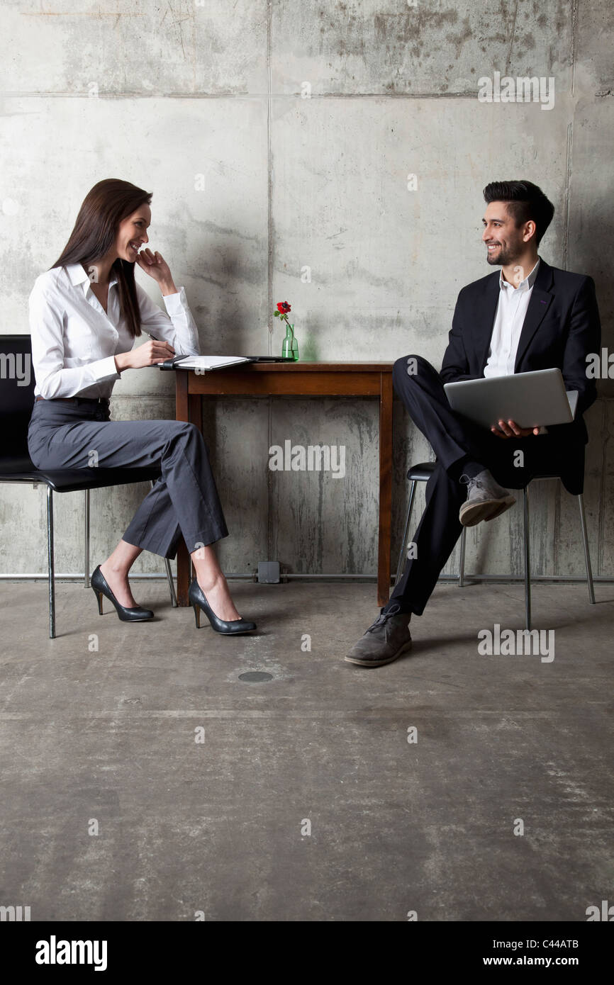Un imprenditore e imprenditrice avente una riunione in un ufficio moderno Foto Stock