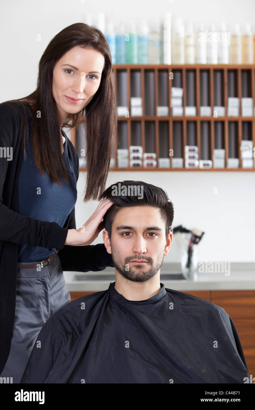 Un parrucchiere styling un cliente i capelli Foto Stock