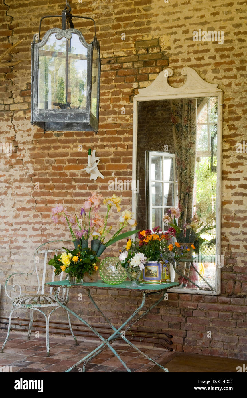 Ferro battuto mobili da giardino e una grande lanterna lungo esterni in mattoni rossi della casa francese di campagna Foto Stock