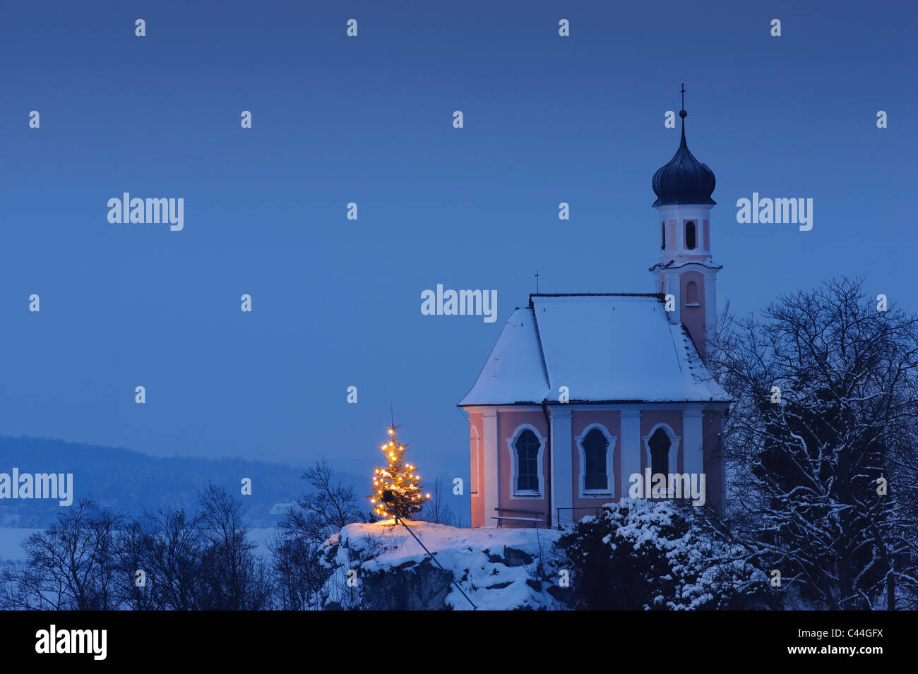 Cappella di natale in inverno con neve di notte e albero illuminato, fotografia scattata in Baviera, Germania Foto Stock