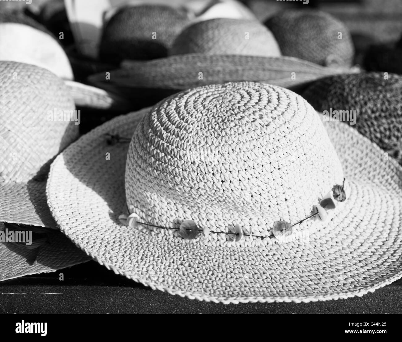 Femmina di cappello di paglia con una collana decorativa utilizzata come una sorta di nastro sul display al di fuori di un negozio in Toscana, Italia Foto Stock