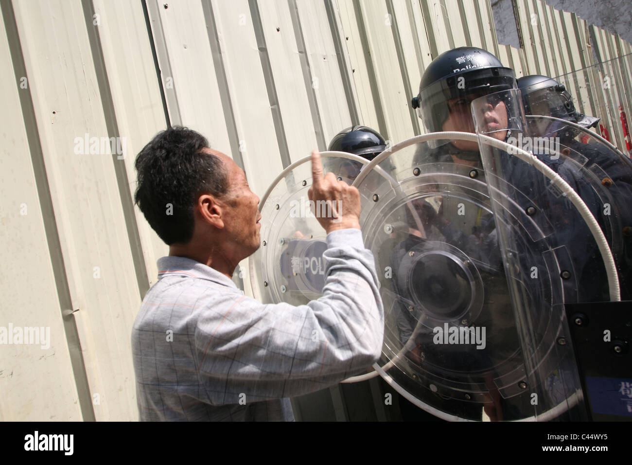 Uomo cinese lotta protesta contro le forze di polizia in una dimostrazione, Macao Foto Stock