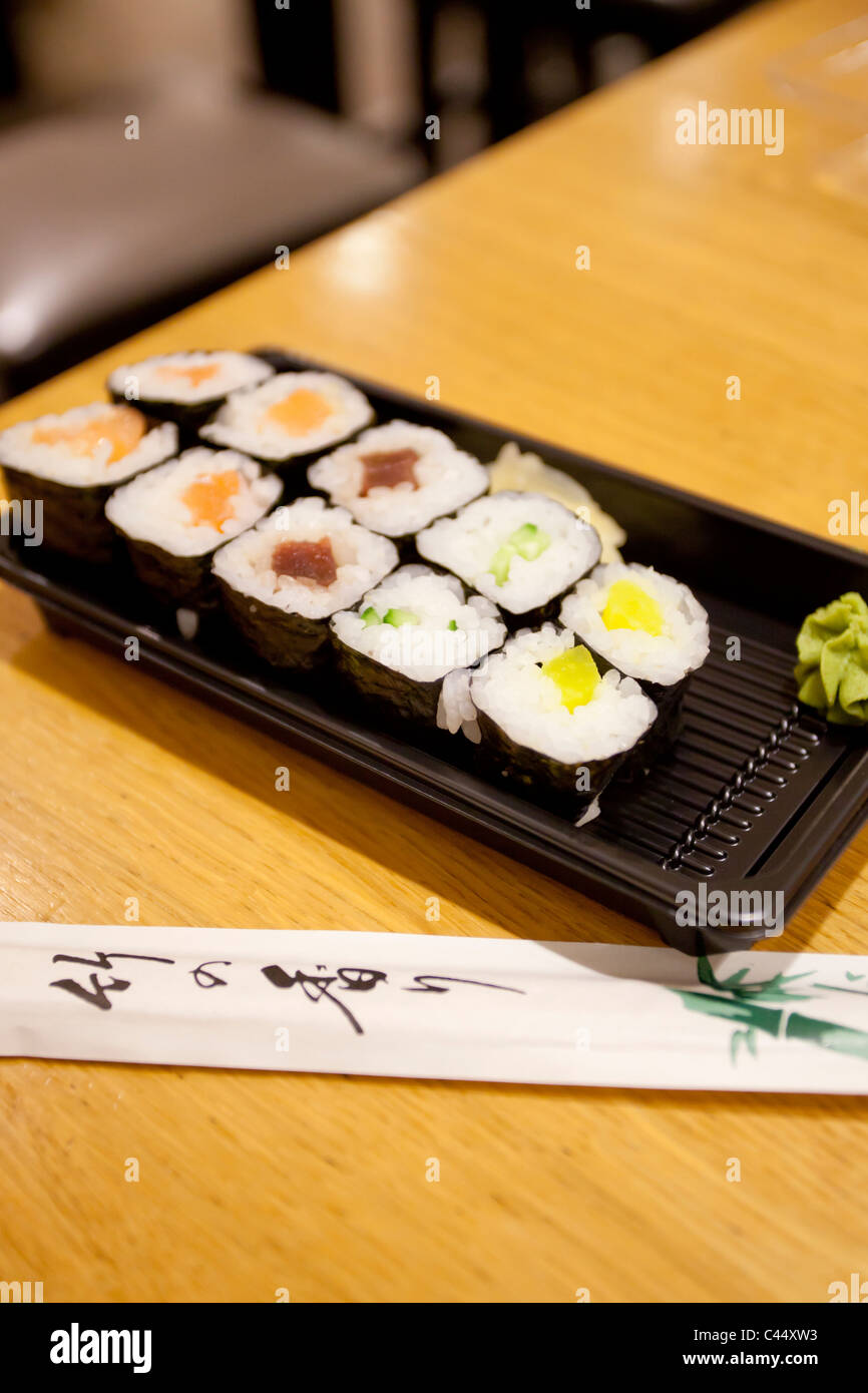 Sushi su un vassoio di plastica con bacchette, vista ravvicinata Foto Stock