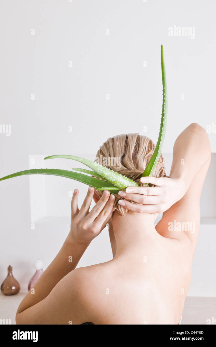 Donna con aloe vera maschera per capelli Foto Stock