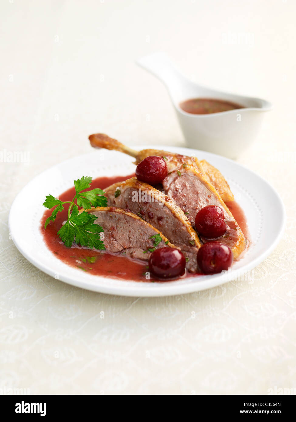 Fette di carne di anatra con ciliegie sulla piastra (dolce e aspro piatto), close-up Foto Stock