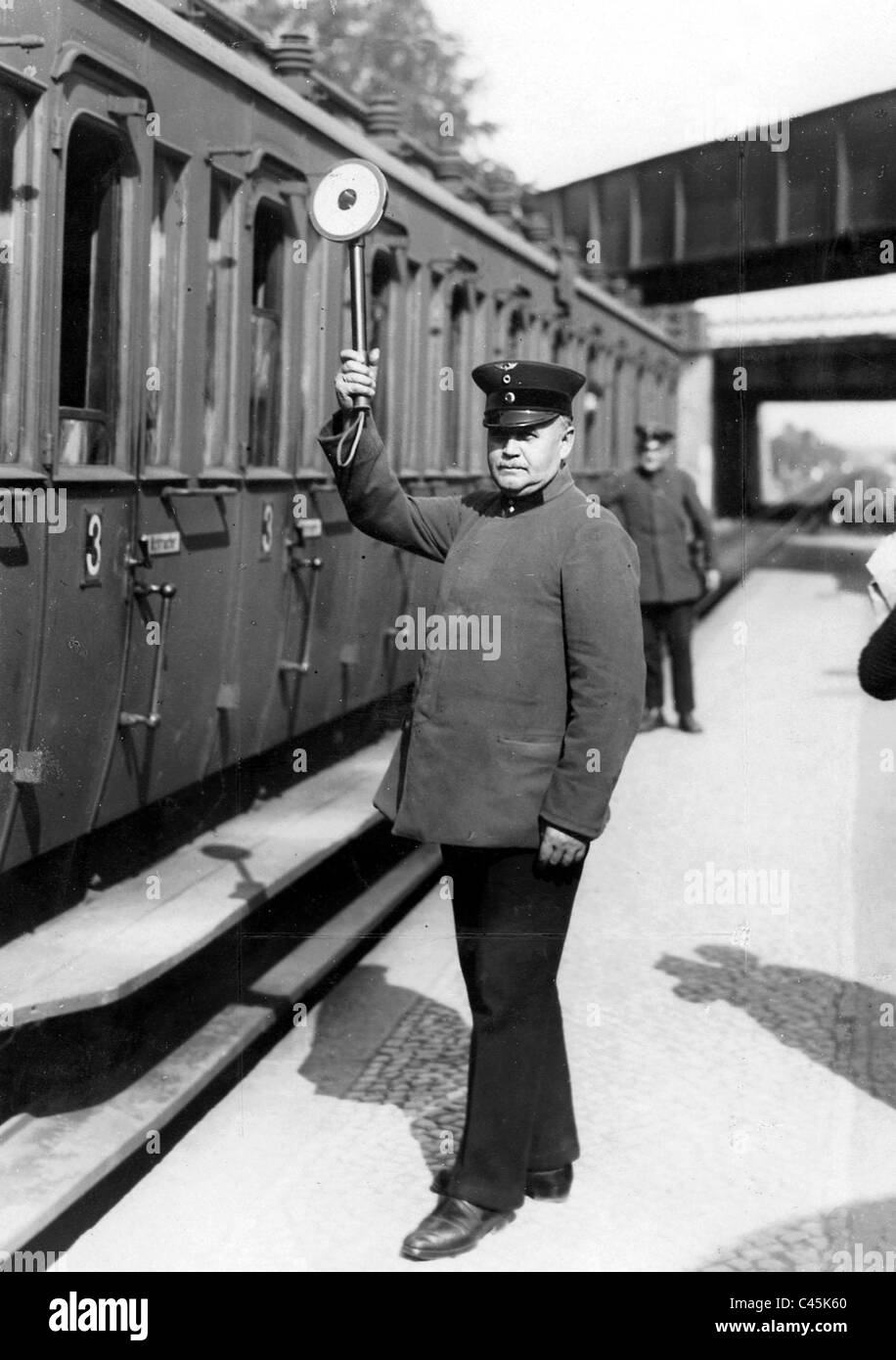Dipendente ferroviario dà il permesso al segnale di partenza, 1930 Foto Stock