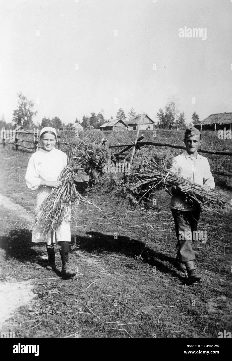 Soldato tedesco con una contadina nel campo lavoro dietro il fronte orientale, 1942 Foto Stock