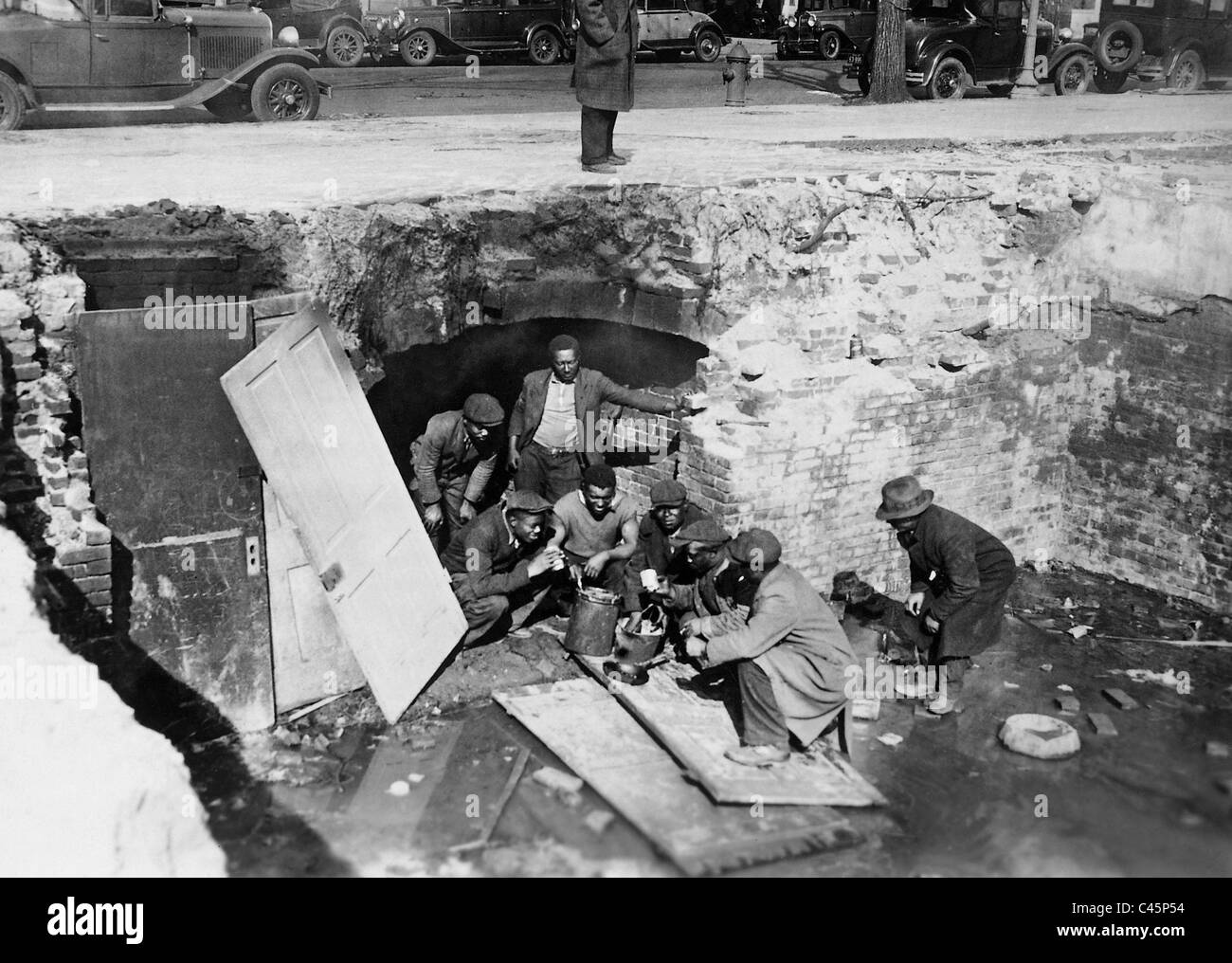 Disoccupati durante la Grande Depressione in una cantina abitazione Foto Stock