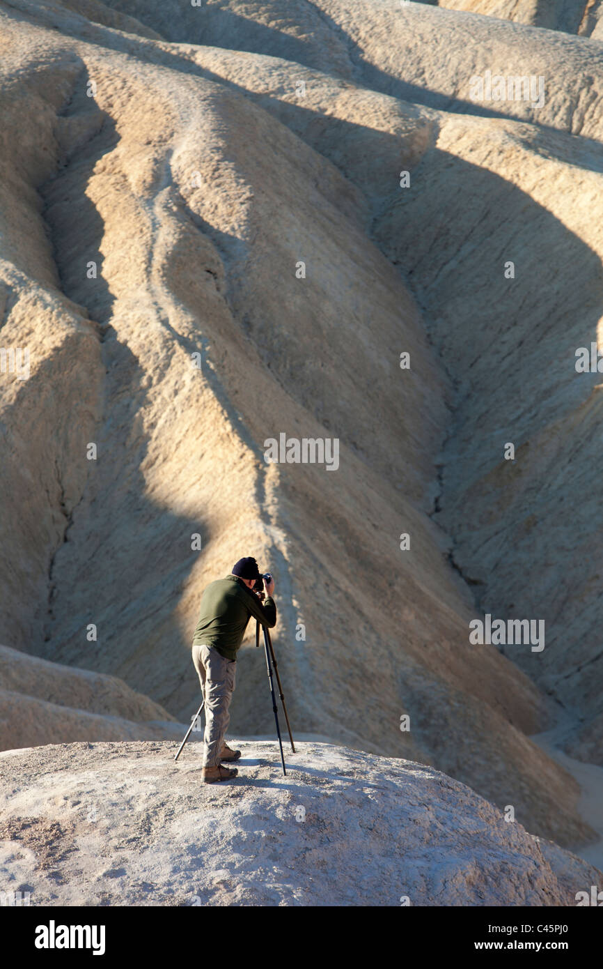 Uomo di fotografare Sunrise vicino Zabriski Point, Parco Nazionale della Valle della Morte, California Foto Stock
