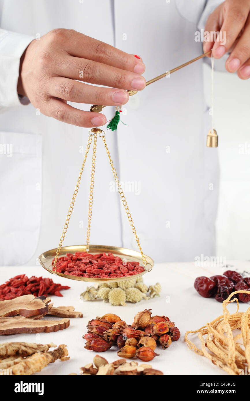 Erborista asiatica del peso di erbe medicinali Cinesi Foto Stock