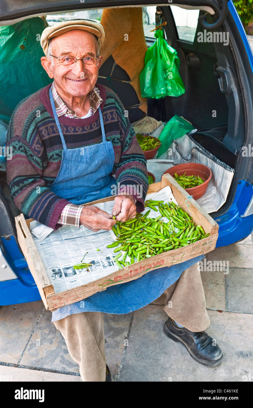 Il vecchio uomo piselli da sgranare al mercato rionale - Francia. Foto Stock