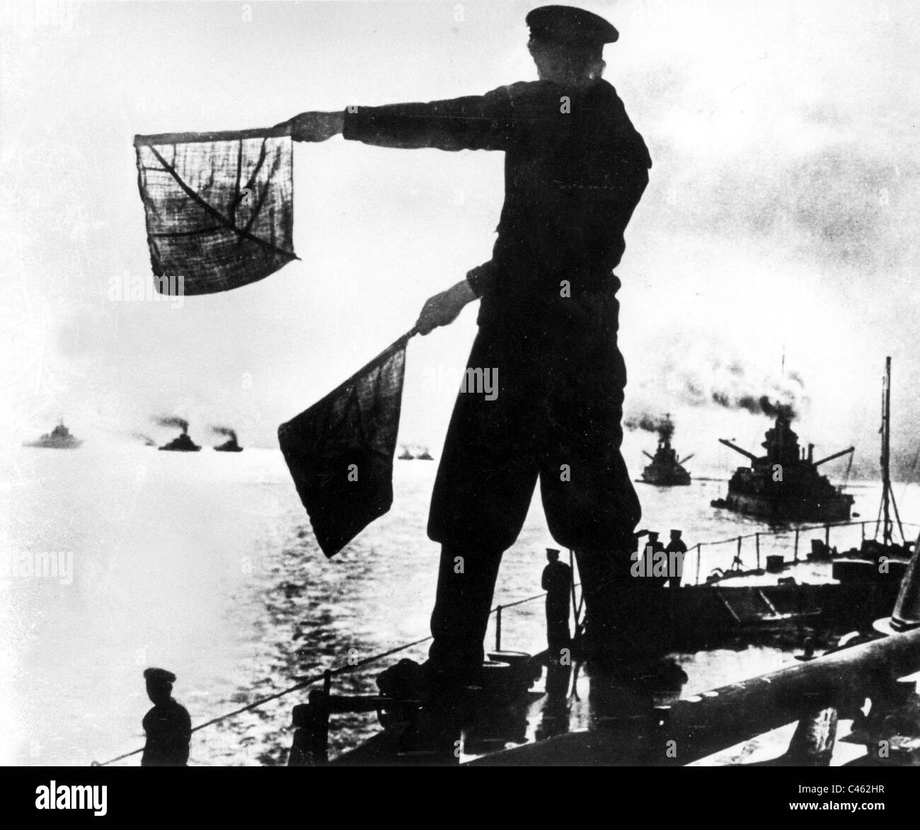 Segnale britannico l uomo dà segnali di bandiera per le navi da guerra Britanniche Foto Stock