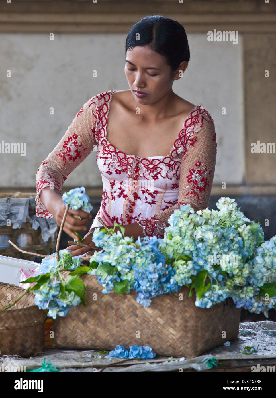 Una donna balinese prepara fiori durante il GALUNGAN FESTIVAL - Ubud, Bali, Indonesia Foto Stock