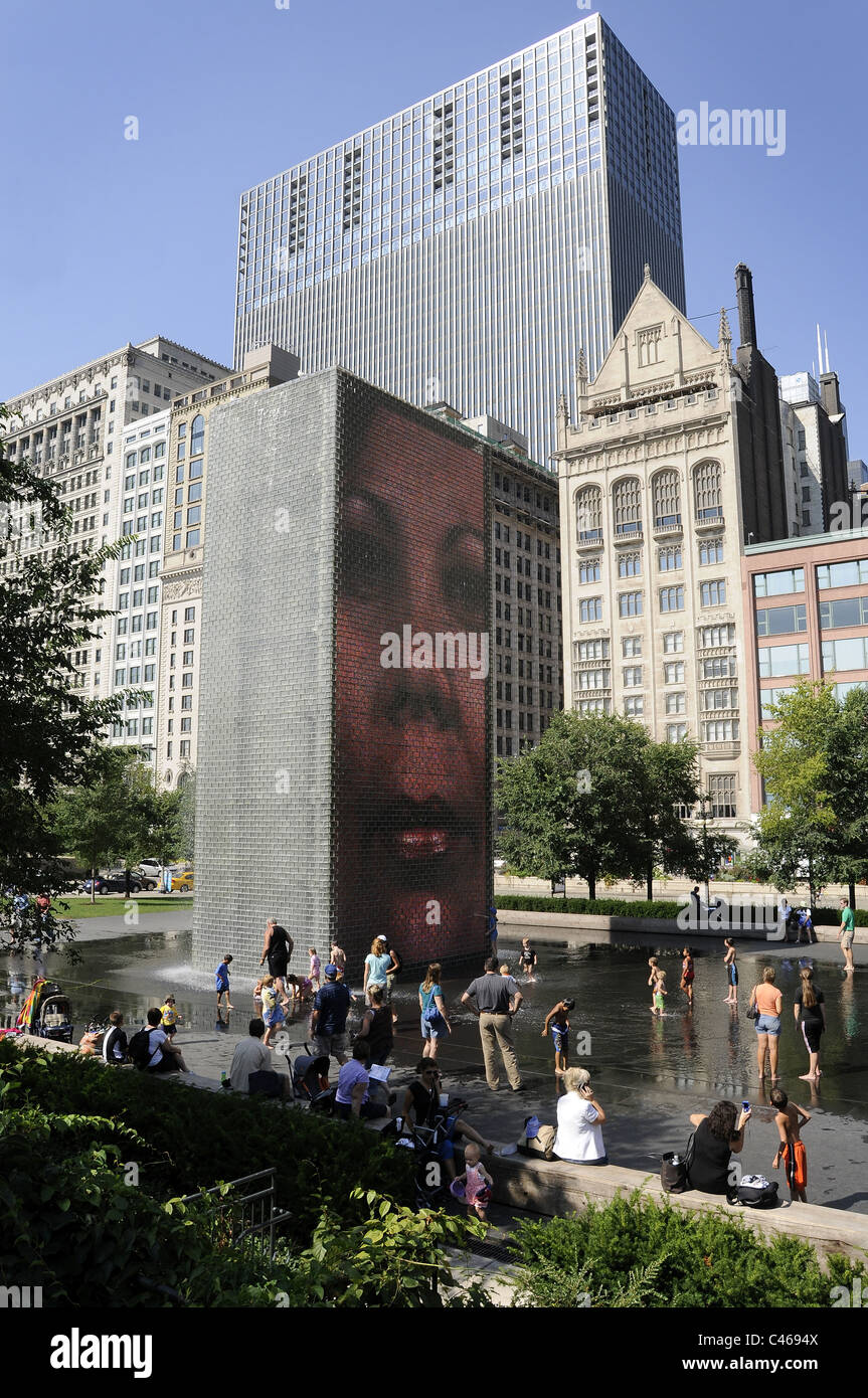 Le persone godono di corona Fontana al Millenium Park di Chicago, Illinois, Stati Uniti d'America su un giorno di estate con lo skyline della città in background. Foto Stock