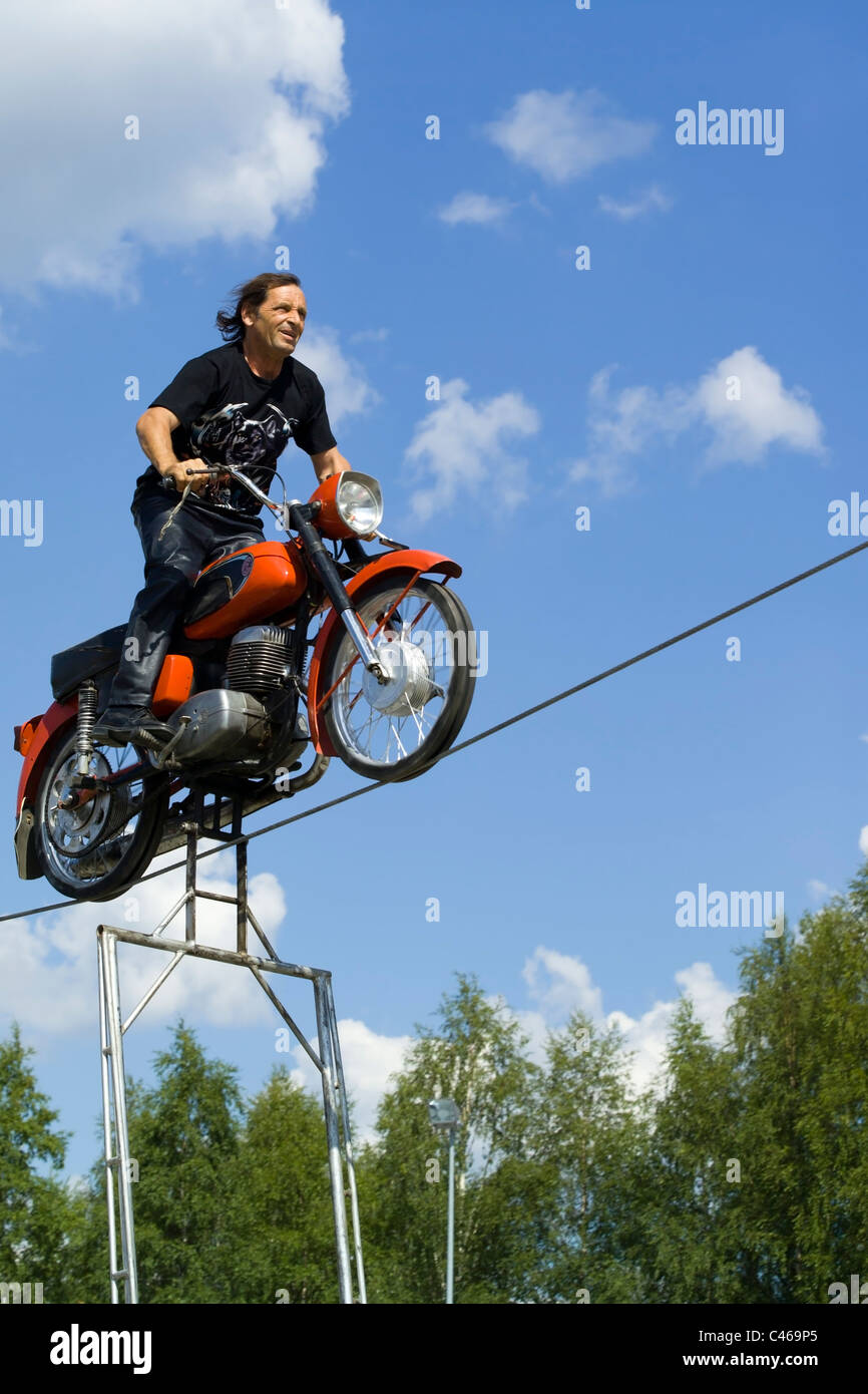 Conducente del motociclo in equilibrio su corda Foto Stock