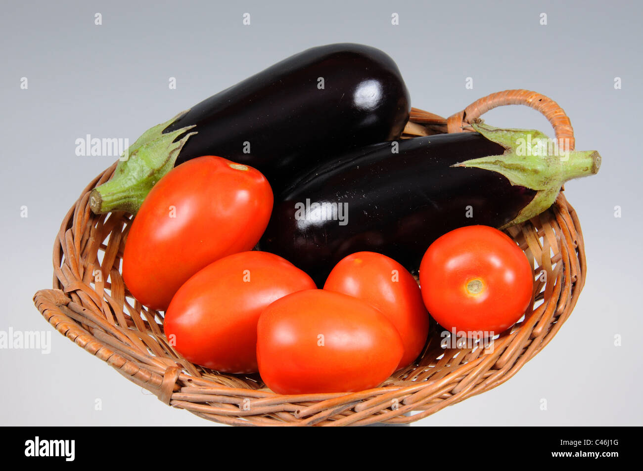 Prugna i pomodori e le melanzane in un cesto di vimini, Calypso, Costa del Sol, provincia di Malaga, Andalusia, Spagna, Europa occidentale. Foto Stock