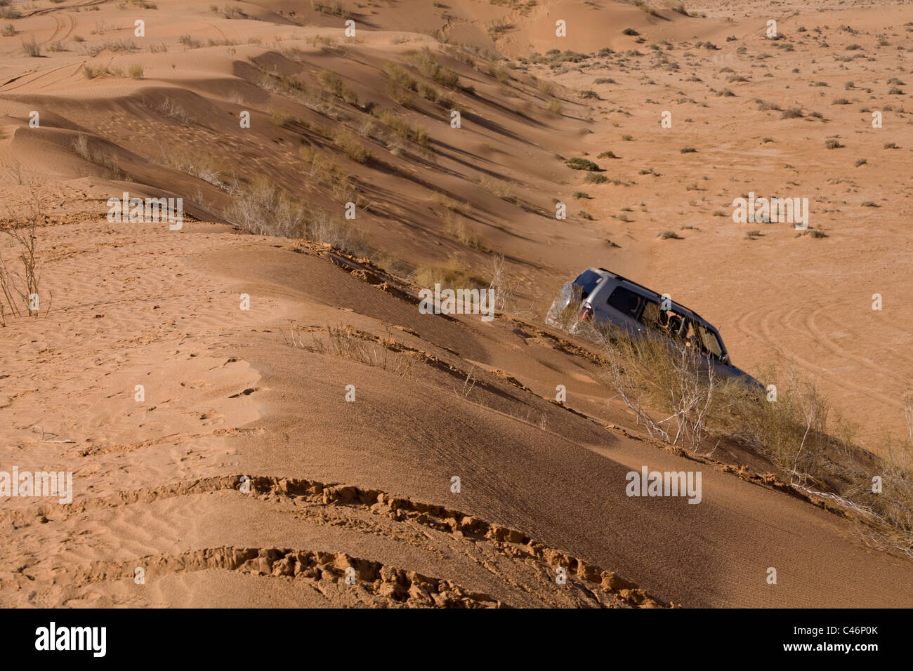 Fotografia di un SUV guidare attraverso una duna di sabbia nel deserto giordano Foto Stock