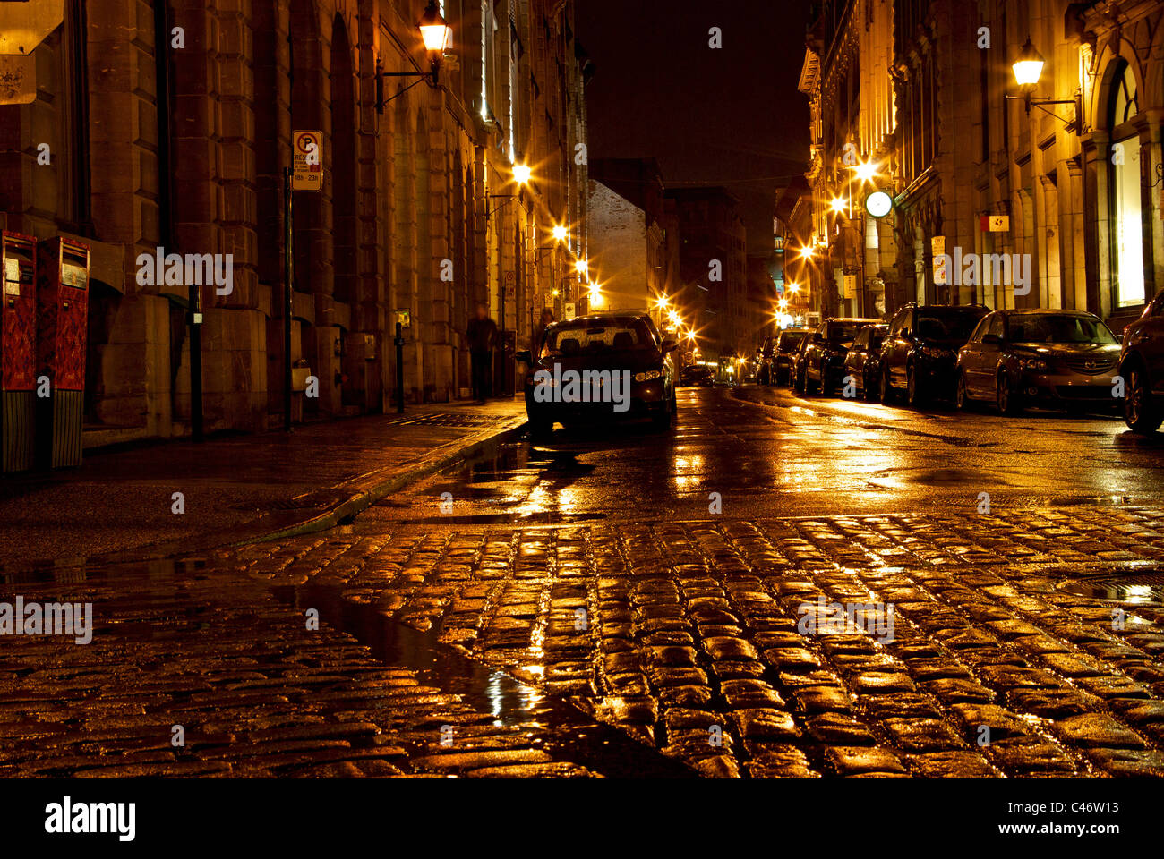 Auto parcheggiate slicked pioggia acciottolato Rue Saint Paul nella storica Città Vecchia Montreal di notte Foto Stock