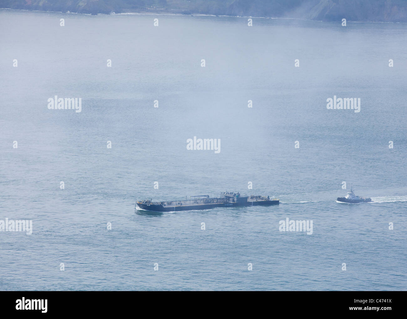Una chiatta merci rende modo nella baia di San Francisco, sotto il cielo di nebbia Foto Stock