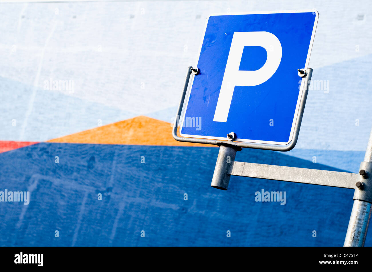 Un parcheggio auto segno davanti di un dipinto luminosamente parete Foto Stock