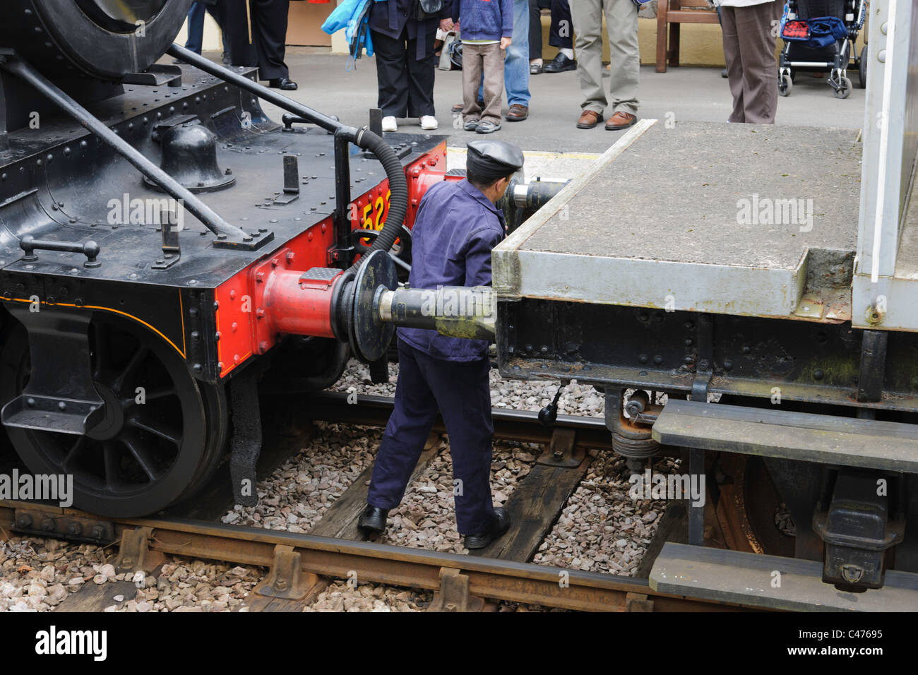 Rampa di accoppiamento del lavoratore locomotiva a vapore per treno Foto Stock