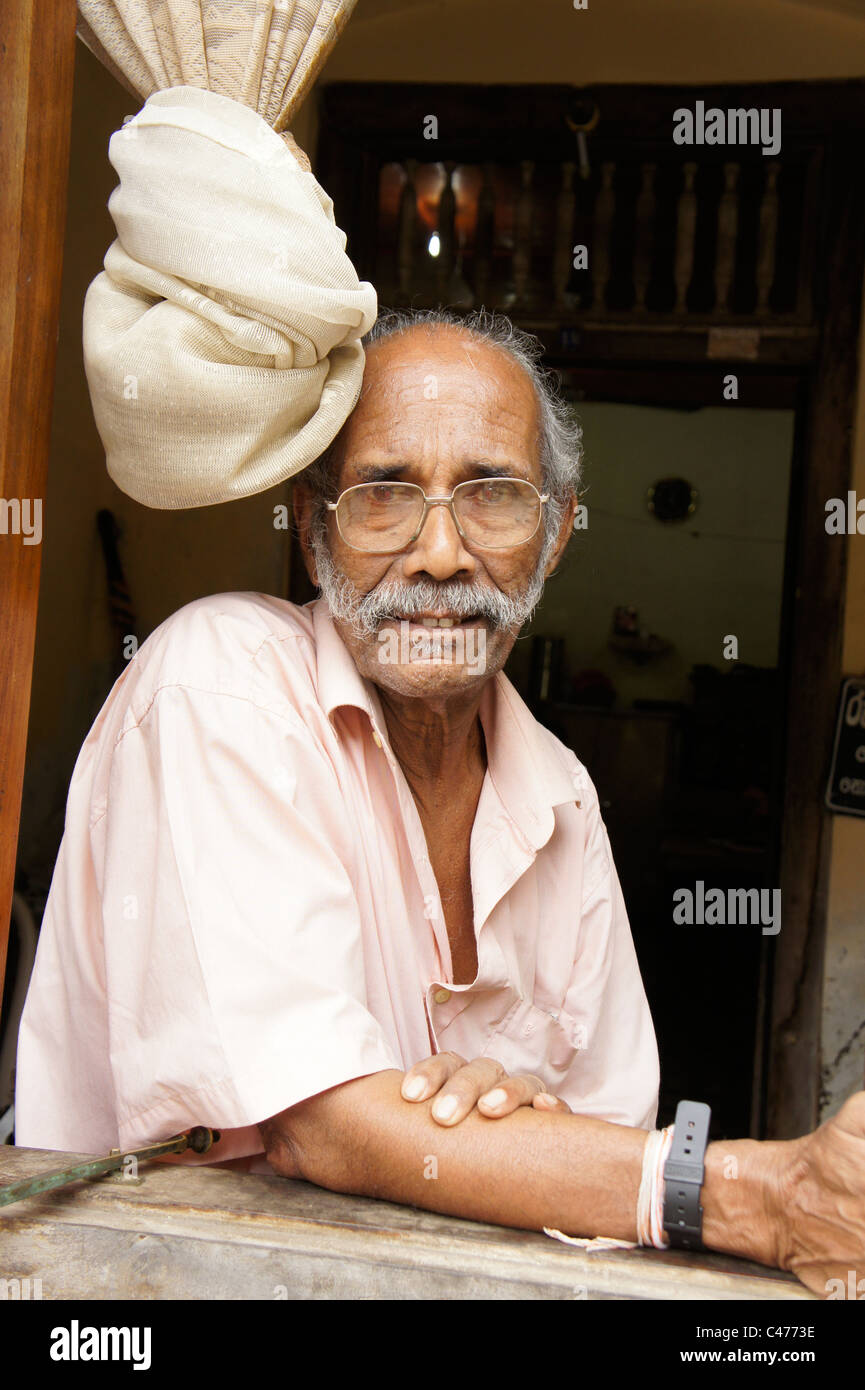 Uomo anziano presso la finestra all'interno dello storico Forte di Galle, Sri Lanka Foto Stock