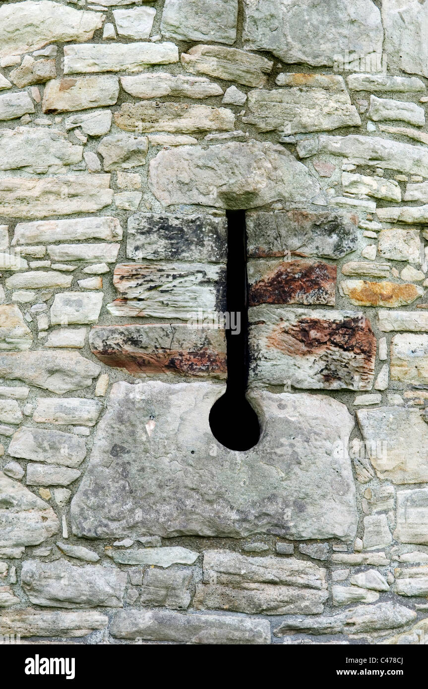 Loop di freccia esteso a prendere la canna della pistola a base. Impostare nella parete medievale di Craigmillar Castle, S.W. di Edimburgo, Scozia, Regno Unito Foto Stock