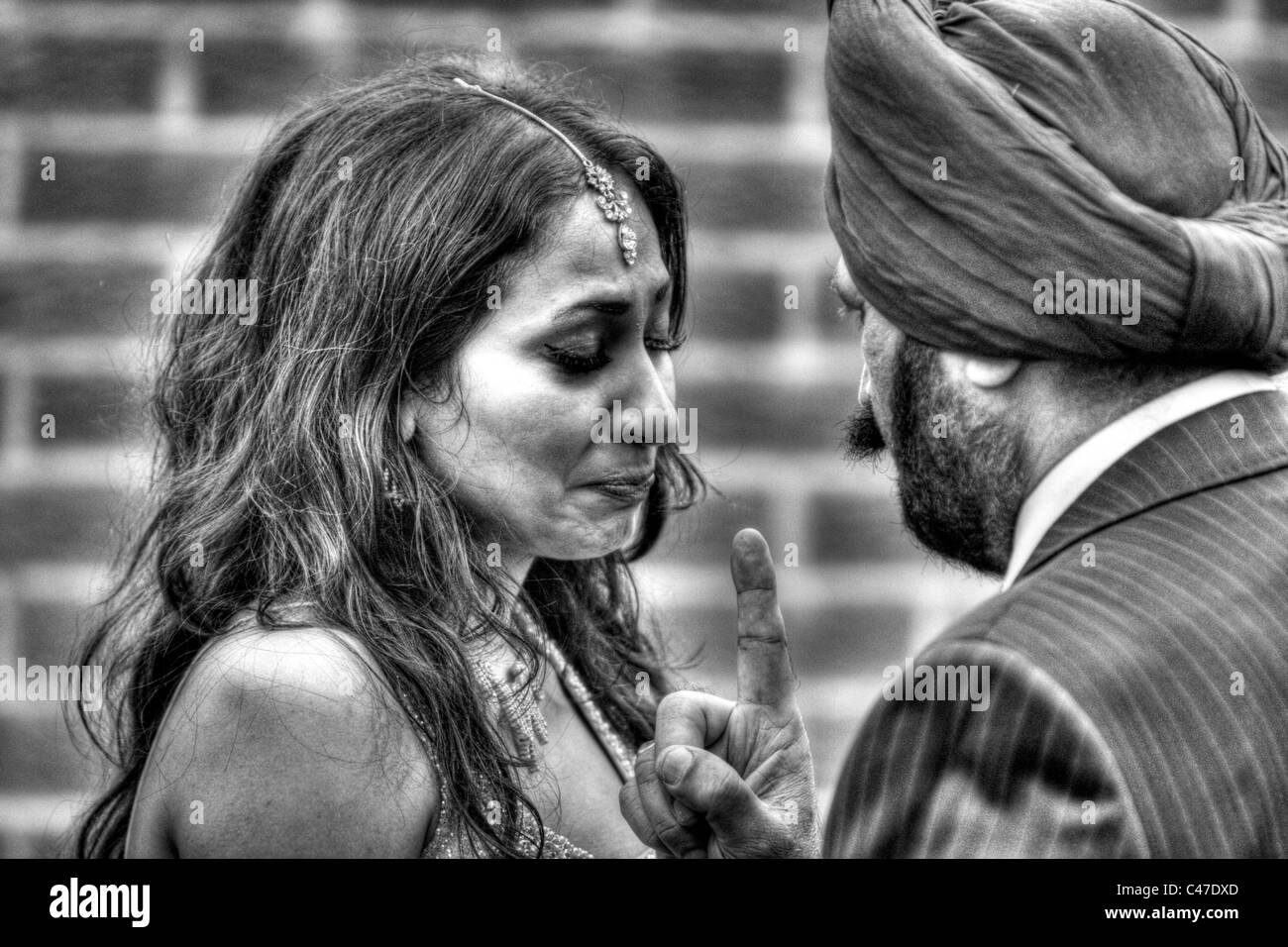 Sconvolto ragazza Sikh musulmano padre sconvolge e indica off profilo figlia in bianco e nero hdr Foto Stock